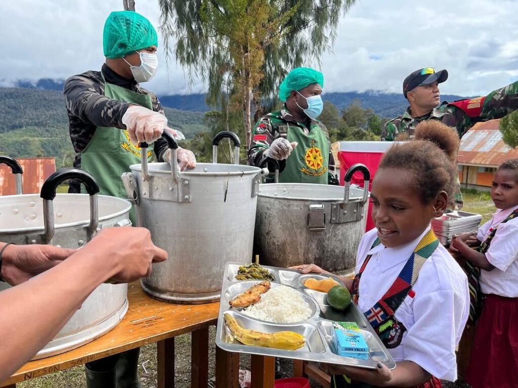 Satgas Yonif 509 Kostrad Bersama Satgas TNI Lainnya Bagikan Makanan Bergizi Gratis untuk Anak Sekolah di Intan Jaya  Intan Jaya, Papua Tengah – Dalam mendukung program Presiden Republik Indonesia dalam peningkatan gizi anak bangsa, Satgas Yonif 509 Kostrad bersama SubSatgaster Yonif 754 Kostrad, Satgas Banmin Koops Habema, dan Koramil Sugapa secara rutin melaksanakan pembagian makanan bergizi gratis kepada anak-anak sekolah di Intan Jaya, Papua Tengah. Meski menghadapi berbagai tantangan, program ini tetap berjalan lancar dan dilaksanakan setiap hari sekolah. Rabu (05/02/2025)  Kegiatan ini bertujuan untuk memastikan anak-anak di wilayah pedalaman Papua mendapatkan asupan gizi yang cukup guna mendukung pertumbuhan dan perkembangan mereka. Prajurit TNI mendistribusikan makanan sehat langsung ke sekolah-sekolah, memberikan nasi, lauk pauk bergizi, sayur, buah, serta susu dan biskuit sebagai tambahan nutrisi bagi para siswa.  Dansatgas Yonif 509 Kostrad, Letkol Inf Dian D Setyadi., menegaskan bahwa kegiatan ini merupakan komitmen TNI dalam mendukung kesejahteraan masyarakat, terutama generasi muda.  “Kami memahami bahwa akses terhadap makanan bergizi masih menjadi tantangan di beberapa daerah. Oleh karena itu, kami berusaha hadir dan membantu agar anak-anak di Intan Jaya bisa mendapatkan nutrisi yang cukup untuk mendukung kesehatan dan pendidikan mereka,” ujar Dansatgas.  Pasiter Satgas Yonif 509 Kostrad, Lettu Chk Irawan Suharto, menambahkan bahwa program ini tidak hanya memberikan manfaat dalam hal pemenuhan gizi, tetapi juga mempererat hubungan antara TNI dan masyarakat.