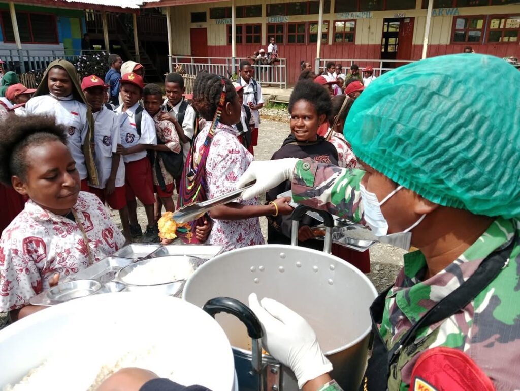Satgas Yonif 509 Kostrad Bersama Satgas TNI Lainnya Bagikan Makanan Bergizi Gratis untuk Anak Se (4)