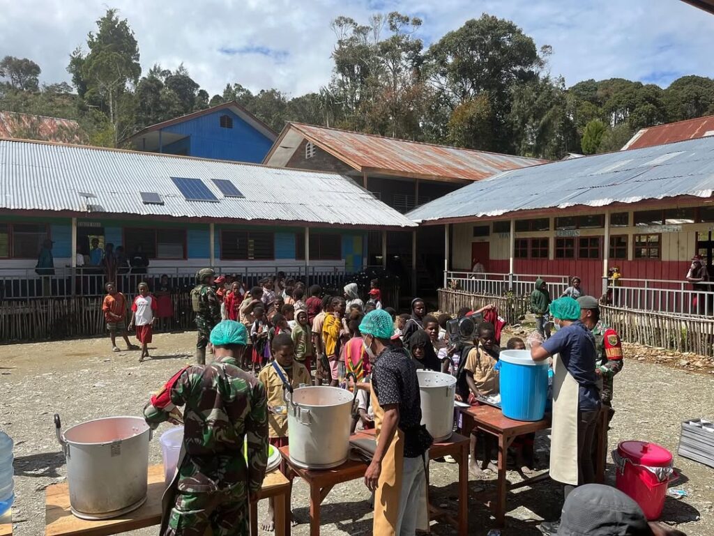 Satgas Yonif 509 Kostrad Bersama Satgas TNI Lainnya Bagikan Makanan Bergizi Gratis untuk Anak Se (5)
